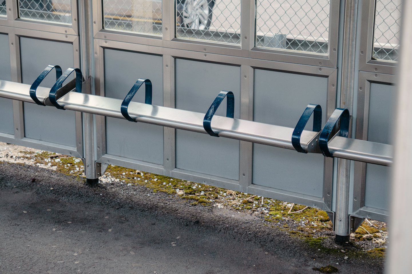 Asfalt üzerinde mavi bölücülü gümüş metal bank.